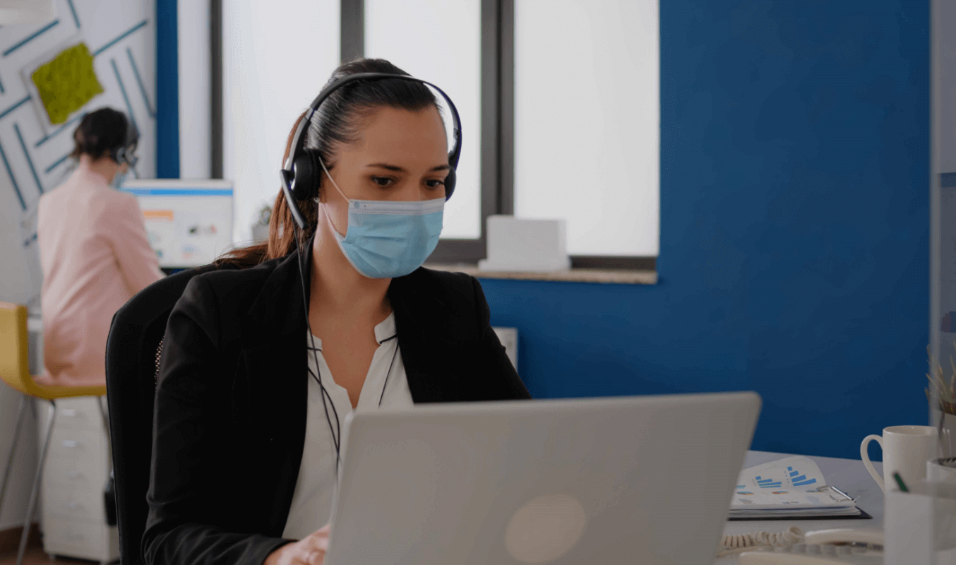 A female employee working at the physical office while social distancing